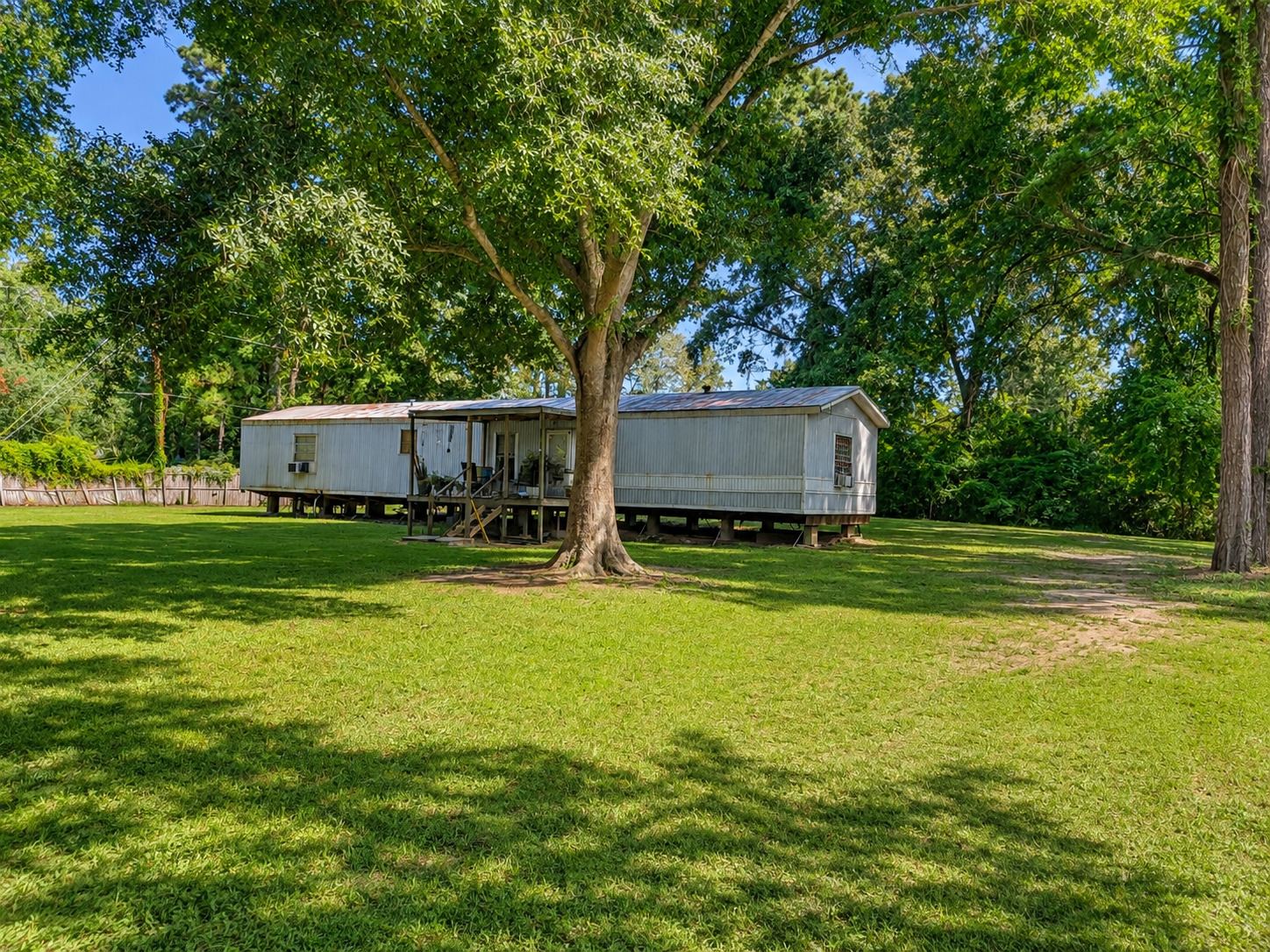 Two platted lots totaling nearly 0.9 acre at 8103 Rolling Oaks Dr N, with the existing home under mature shade trees.