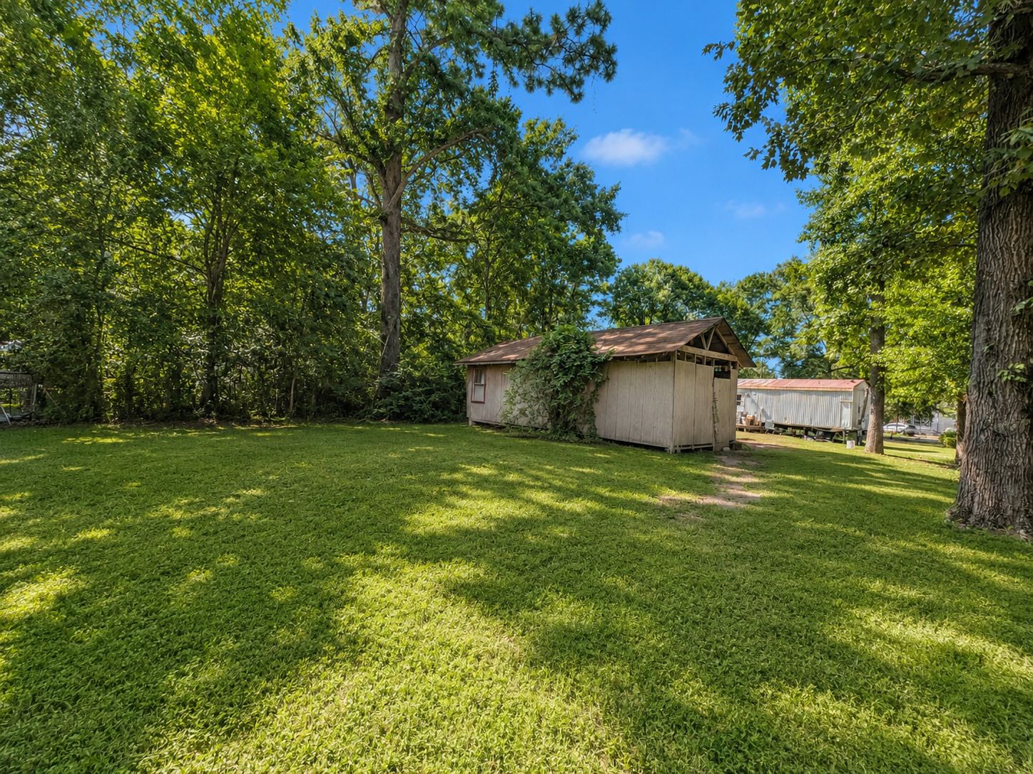 Barn-style outbuilding on the rear lot among trees